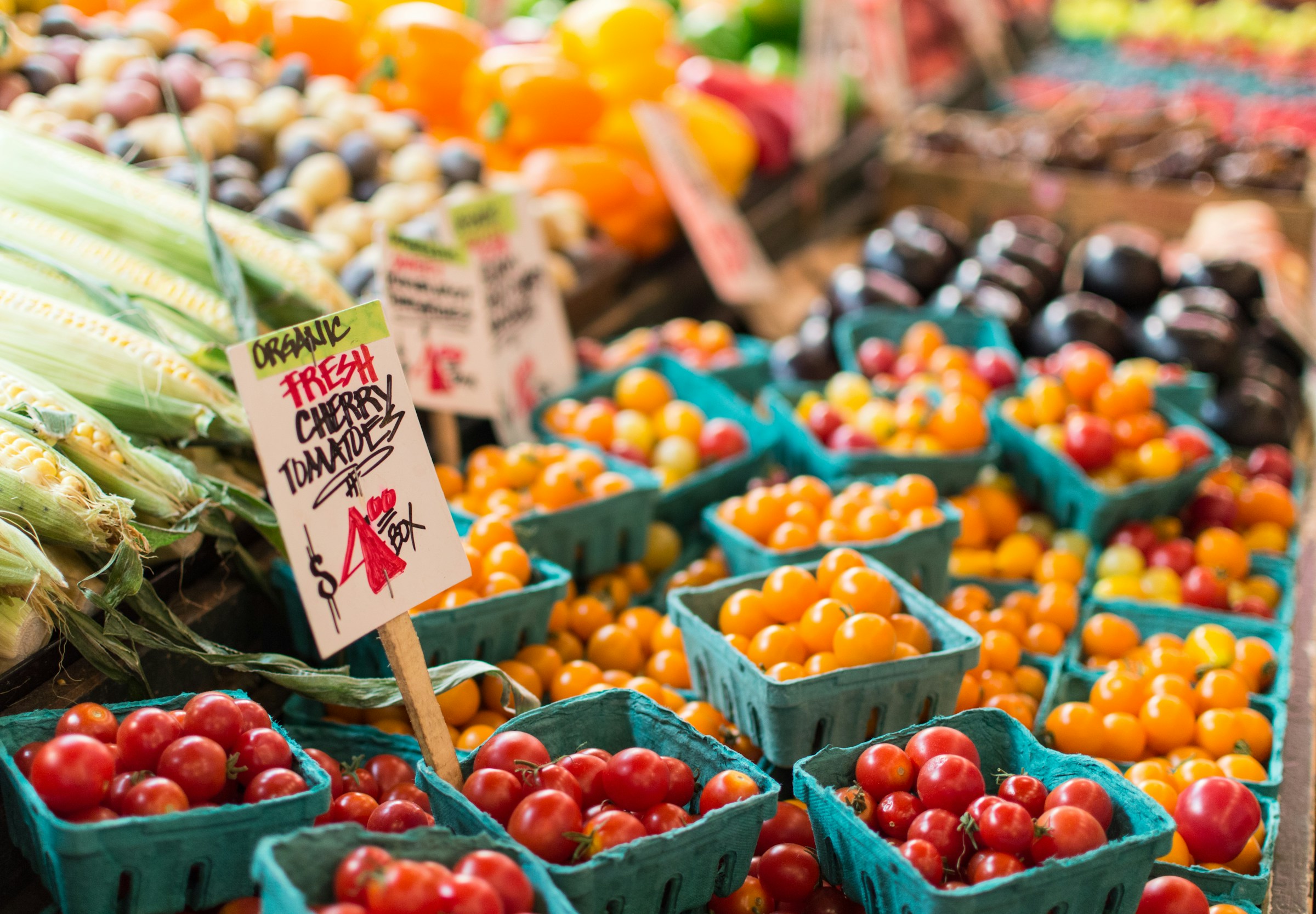 Fresh tomatoes displayed in blue baskets at a vegetable market for a blood pressure diet