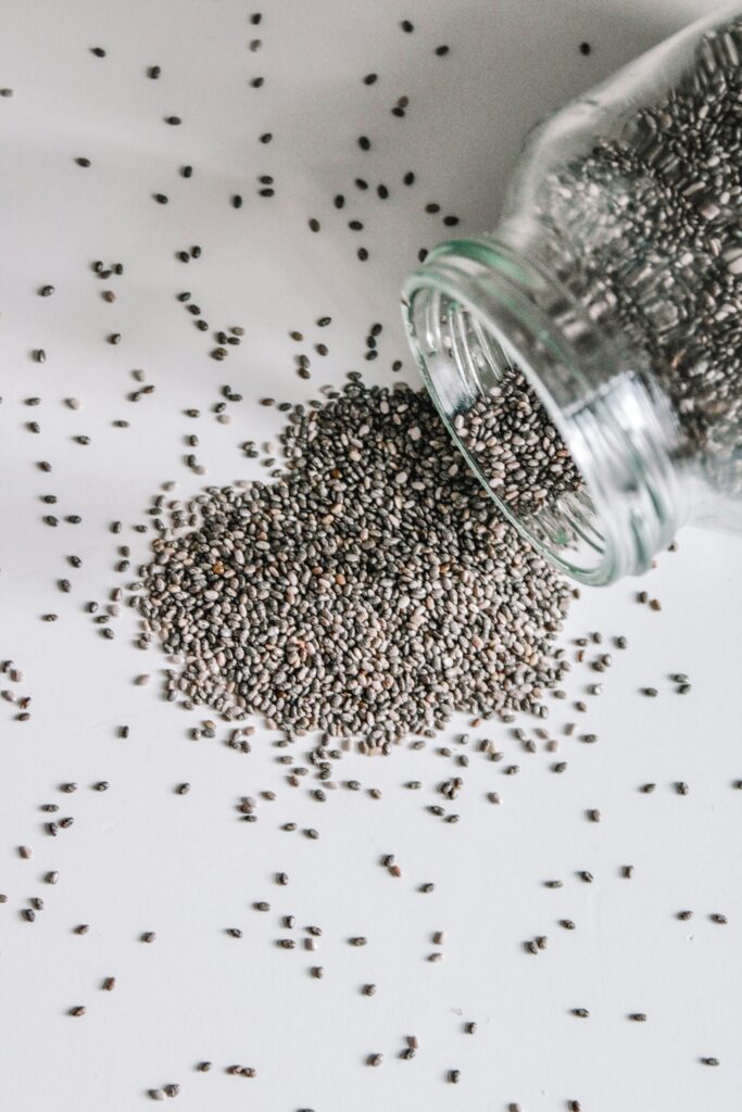 A clear glass jar filled with dry chia seeds