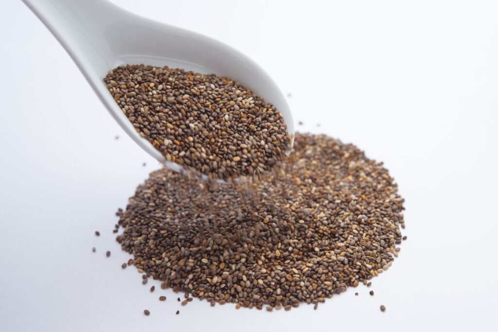 Chia vs flax seeds: a close-up of dark chia seeds on a white spoon