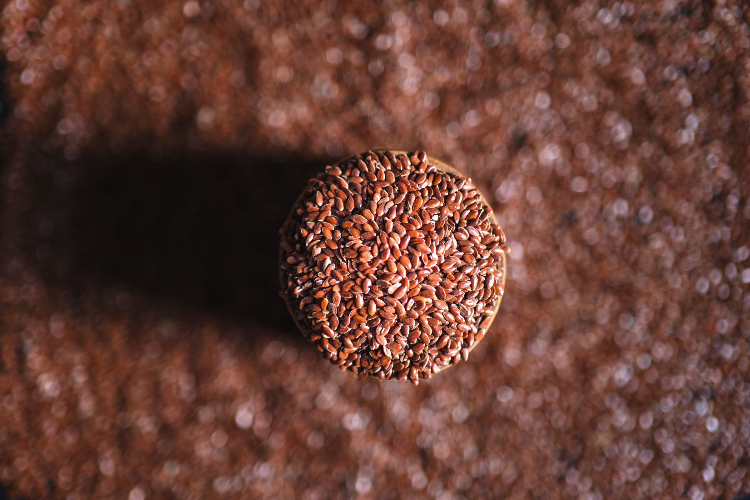 Comparing chia vs flax seeds stored in a clear glass jar with some scattered on the table
