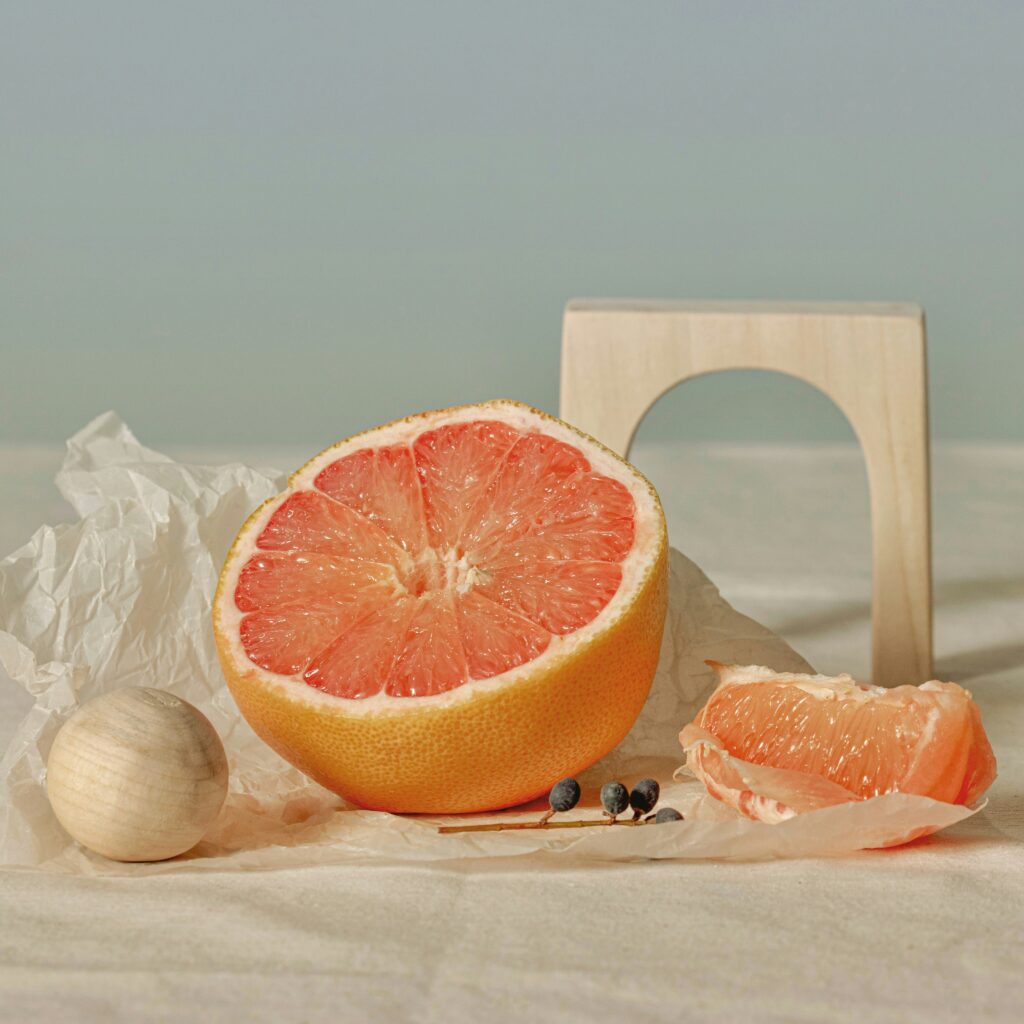 A halved grapefruit sitting on a wooden table representing blood pressure medication food interaction