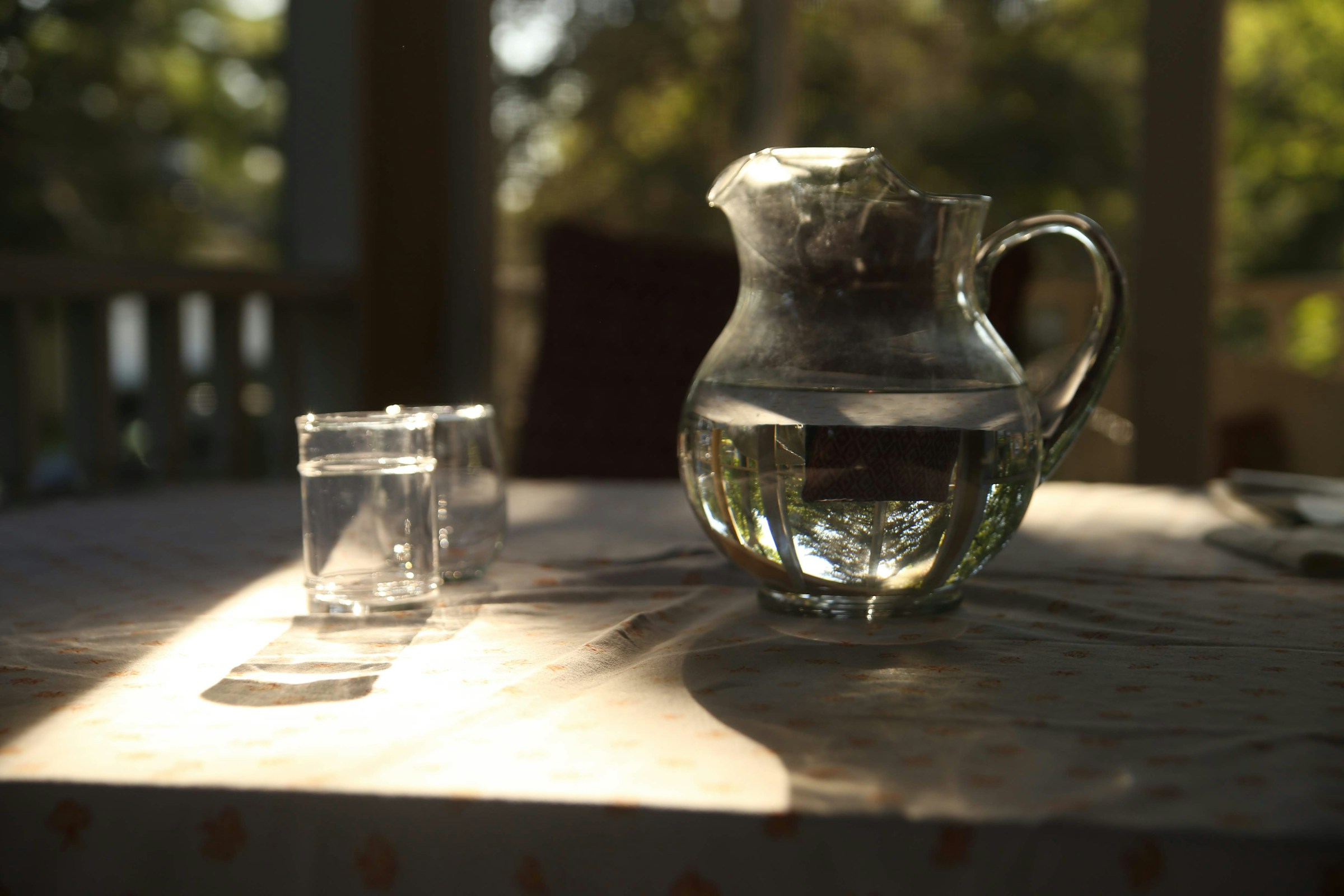 Clear glass pitcher and drinking glasses filled with clean safe water for hepatitis recovery