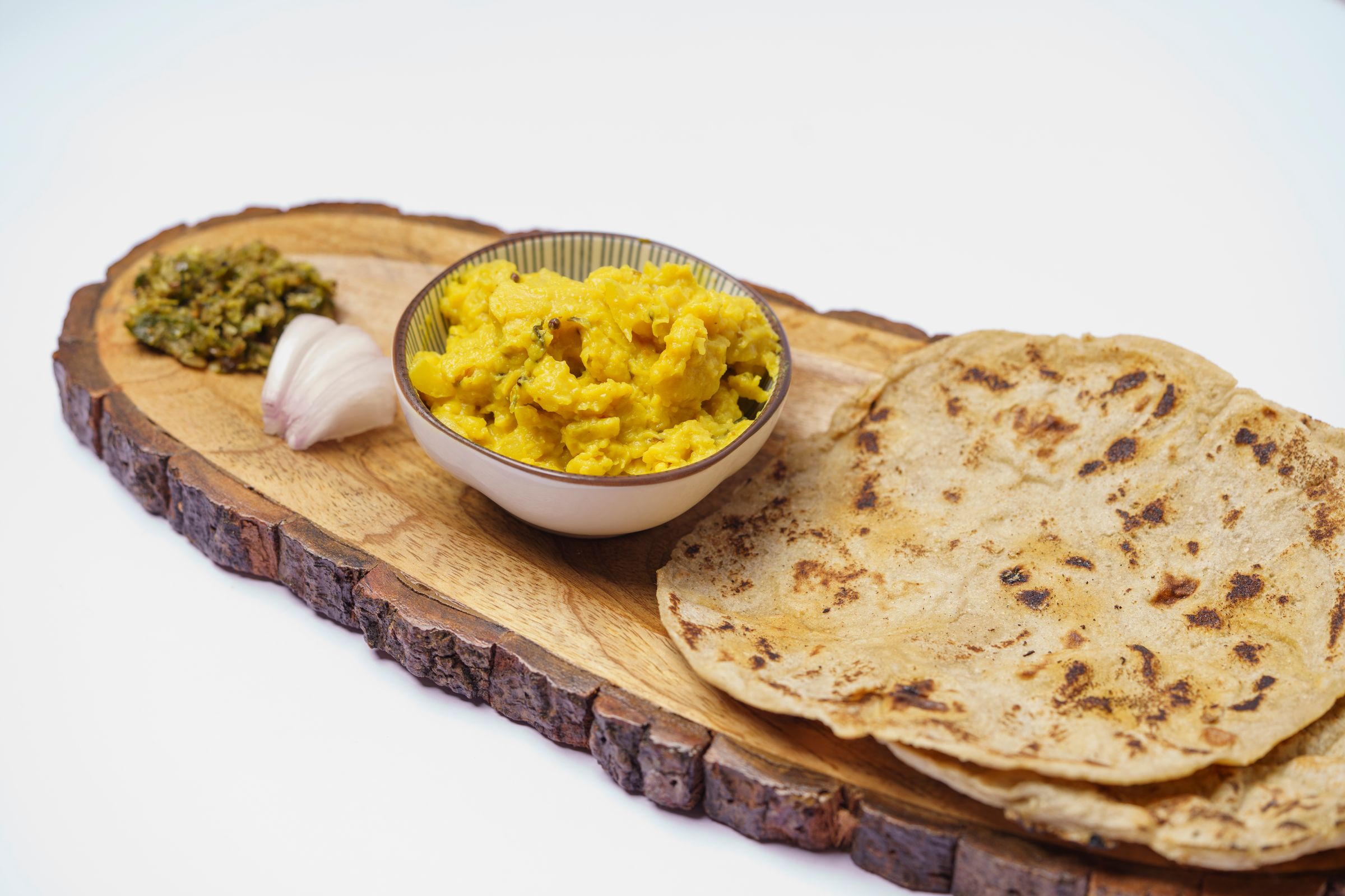 Cooked yellow daal and whole wheat roti served on a wooden platter as part of a nourishing recovery diet