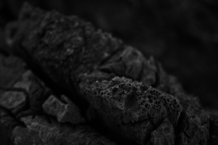 Shilajit side effects: close-up of dark, porous raw mineral rocks before purification