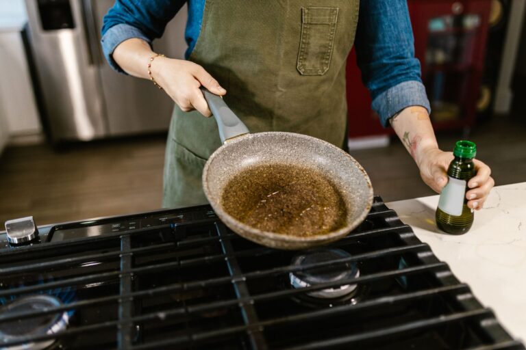 Trans fats in banaspati: a chef pouring liquid cooking oil into a frying pan as a healthier alternative