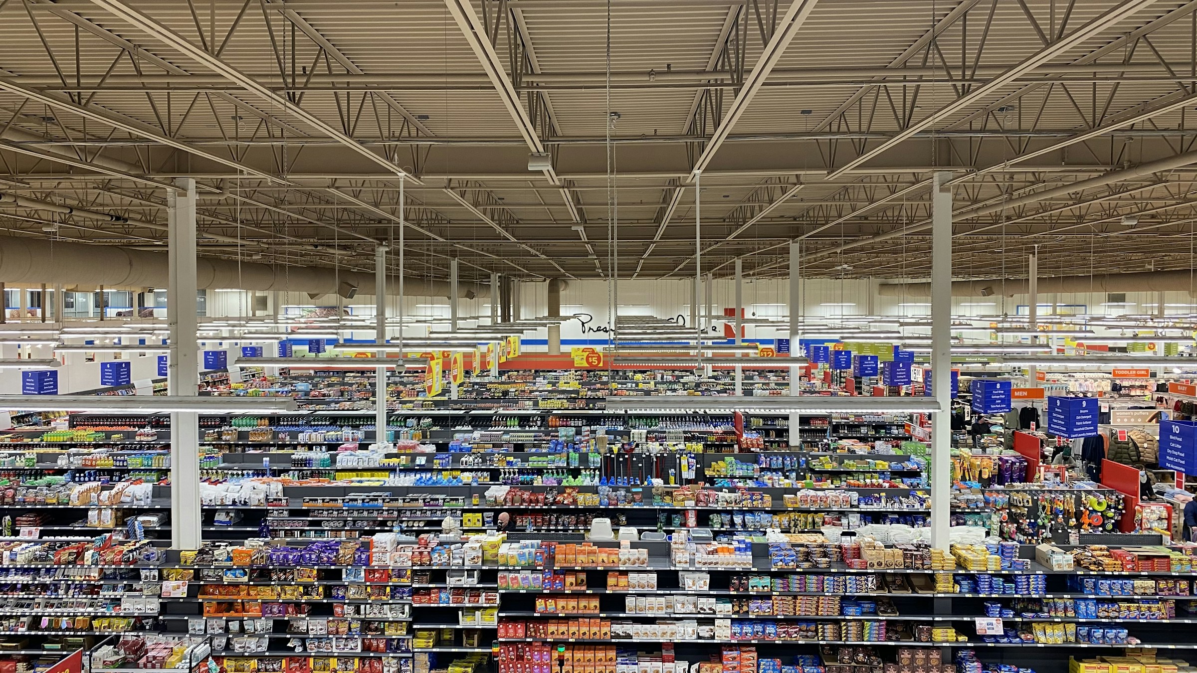 Buying banaspati: a wide view of supermarket aisles from above showing shelves stocked with various foods