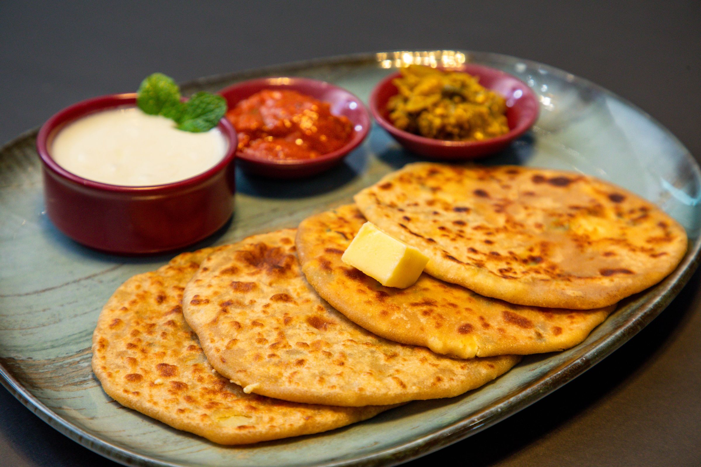 Traditional banaspati ghee cooking: flaky parathas served on a plate with condiments