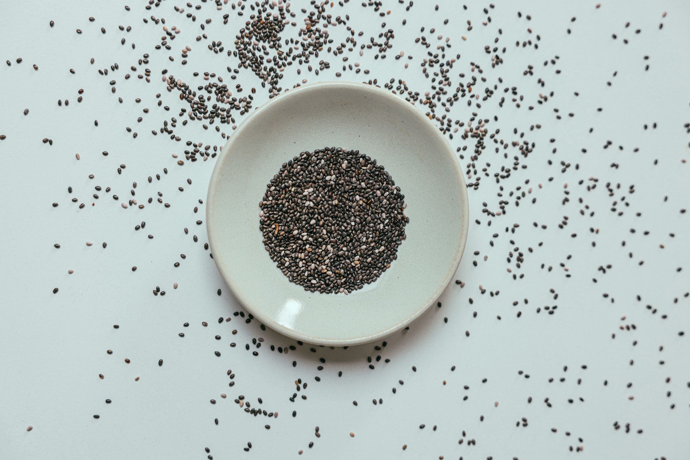 Dry tukh malanga seeds resting in a white bowl before soaking